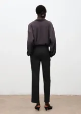 Pantalón de corte recto y tiro medio, color gris oscuro, con bolsillos laterales y pascadores para cinturón.
