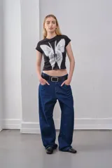 Remera corta negra de algodón con estampado de mariposa blanca.