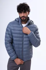 Campera puffer con capucha, cierre frontal y diseño acolchado horizontal.
