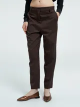 Pantalón sastrero de corte recto, color marrón, con cierre frontal, botón oculto, pasacintos y bolsillos laterales.