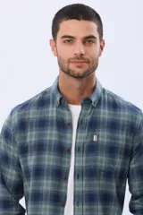 Camisa de viyela a cuadros en tonos marrón, azul marino y gris, con cuello clásico, cierre frontal con botones, mangas largas y un bolsillo en el pecho.