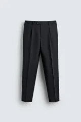 Pantalón de traje negro de corte regular fit, con pinzas delanteras, bolsillos laterales y cierre frontal con cremallera y botón.