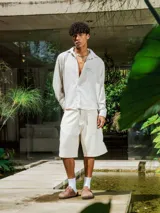 Camisa de lino con diseño de cuadrillé en tonos blanco y beige, de manga larga y cuello clásico. Presenta una pequeña estampa en el pecho y una estampa en la espalda, con un calce holgado y relajado.