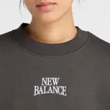 Buzo de cuello redondo New Balance, confeccionado en tejido de vellón de algodón cepillado. Presenta un diseño de corte extragrande con mangas largas y puños ajustados. Incluye un gráfico bordado con puntada de satén en el centro del pecho.