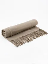 Pashmina de textura suave y acabado liso, con detalle de flecos en los extremos.