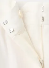 Pantalón de corte recto y tiro regular, color blanco, con bolsillos laterales y pinzas en la parte delantera.