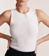 Musculosa de punto color rojo, con cuello redondo y detalle de ondas en sisas y cuello.