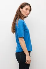 Remera blanca de manga corta raglán con detalle de vainillas, cuello redondo y corte clásico.