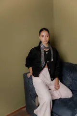 Bomber de corte corto y silueta relajada, confeccionada en paño de lana con cashmere. Presenta cuello redondo, cierre frontal con botones y mangas con puños elásticos.