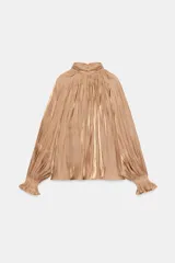 Camisa satinada color tostado con cuello alto fruncido, mangas largas amplias y puños elásticos con volados.