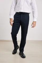 Pantalón de vestir azul marino, de corte recto, con bolsillos laterales y traseros. Se ajusta a la cintura con cinturón de cuero negro.