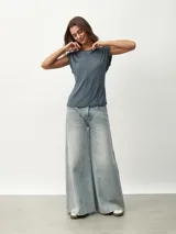 Remera blanca de corte clásico con cuello redondo y mangas cortas con detalle de hombreras.