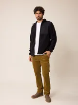 Campera de polar color beige con cierre frontal completo y cuello alto. Presenta un bolsillo en el pecho con cierre y detalle de parche con logo. El diseño combina paneles de tejido polar con detalles en tejido técnico en la zona del pecho.