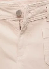 Pantalón de jean estilo wide leg color beige, con tiro alto, cierre frontal de cremallera y botón, y dos bolsillos de parche en la parte delantera.
