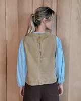 Chaleco de denim con diseño a rayas verticales, cuello redondo y corte recto. Presenta pespuntes en contraste y detalle de aberturas en los laterales.