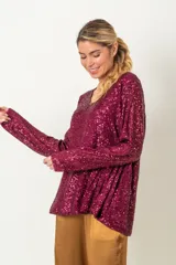 Blusa negra de paillettes con escote en V y mangas largas.