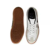 Championes Puma modelo Palermo LTH, con diseño de perfil bajo, cuerpo de cuero blanco, detalles en gamuza gris y franja lateral en color lila. Cuenta con suela de goma color caramelo y logo dorado en el lateral.