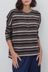Remera de manga larga con diseño de rayas horizontales en tonos marrones, beige y rojizos. Presenta cuello redondo y un detalle bordado en el pecho.