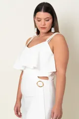 Mono blanco de crepe de seda con corte en la cintura, volados en el busto y espalda y detalle de perlas en los breteles.