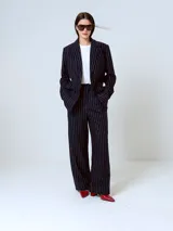 Pantalón de vestir negro con finas rayas verticales blancas, corte recto y tiro alto.