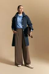 Trench azul marino de corte clásico con cuello amplio, botones frontales grandes en color beige, y detalles en los hombros.