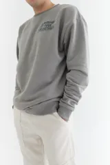 Buzo gris de algodón con corte oversize, cuello redondo y puños y cintura acanalados. Estampa frontal con texto "Manage Your Resistance" en letras de estilo graffiti.