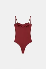 Body lencero color bordó de poliamida, con escote corazón con aro, tirantes finos regulables y cierre inferior a presión.