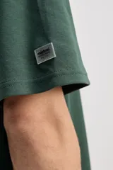 Remera oversize de manga corta color marrón con estampa pequeña en el pecho y estampa geométrica en la espalda.