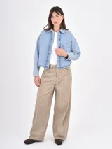 Sobrecamisa de denim en tono azul claro, con corte oversize, cuello clásico, cierre frontal con botones metálicos y un bolsillo de parche en el pecho.