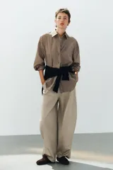 Camisa de popelina a rayas marrones, blancas y celestes, con cuello clásico, manga larga, bolsillo frontal de parche y cierre de botones.