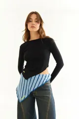 Top de manga larga color blanco, confeccionado en tejido de punto acanalado con diseño irregular y aberturas para los pulgares en los puños.