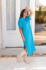 Vestido camisero de muselina color negro, de largo midi, con cuello clásico, manga corta y cierre frontal con botones.