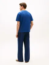 Remera de corte amplio y hombros ligeramente caídos, confeccionada en punto de malla de mezcla de algodón en color azul. Presenta cuello redondo, mangas cortas y un bolsillo de parche en el pecho con el logo de Tommy Hilfiger bordado.