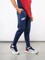 Pantalón de entrenamiento Umbro del Club Nacional de Football, color azul marino. Presenta un diseño técnico con paneles reforzados en la zona de las rodillas, escudo del club en el muslo derecho y logo de la marca en el izquierdo.