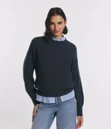 Suéter de punto azul marino, con cuello redondo y manga larga.