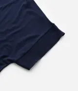 Blusa azul marino de crepé, con escote en V y mangas cortas. Presenta detalles de punto en el cuello y los puños de las mangas, así como flecos en los laterales de los puños.