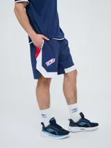 Bermuda deportiva Umbro del Club Nacional de Football, modelo Pro Training, de color azul marino con detalles blancos en el dobladillo. Presenta el escudo del club en una pierna y el logo de la marca en la otra.