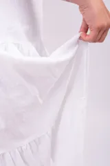 Pollera larga blanca de tiro alto, con cintura elástica y diseño amplio de volados escalonados.