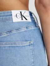Jean skinny de tiro alto Calvin Klein, color celeste, con bolsillos delanteros y traseros, cierre con cremallera y botón, y etiqueta de cuero con logo en la parte trasera.