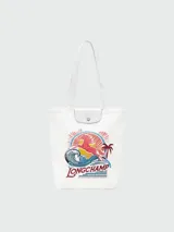 Bolso tote mediano de lona color blanco con diseño estampado frontal que incluye un caballo, olas, un sol y palmeras, junto al logo de la marca. Presenta detalles en cuero blanco en la solapa superior y asas largas para llevar al hombro.