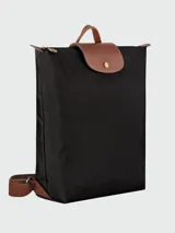 Mochila de diseño minimalista en color beige, con solapa y asa superior en cuero marrón texturizado. Cuenta con correas ajustables en color marrón y cierre principal.