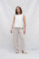 Musculosa de lino color blanco con paneles laterales en color beige, escote redondo y espalda con pliegues y cierre con botones.