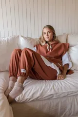 Pantalón de jogging color ladrillo con elástico en la cintura y logo estampado en la pierna.