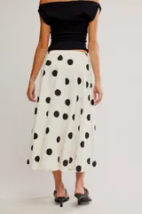 Falda midi de corte A y cintura baja, confeccionada en popelina de algodón color marrón terracota con estampado de lunares celestes.