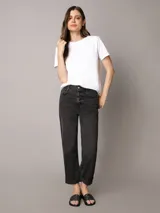 Ojotas Calvin Klein con diseño de monograma de la marca en color beige sobre fondo negro. Presentan una suela anatómica contorneada para mayor confort y una tira superior de material sintético.
