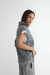 Chaleco de punto gris con cuello alto, diseño sin mangas y corte holgado.