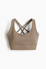 Top deportivo color marrón topo, con escote redondo y copas forradas con relleno extraíble. Presenta breteles dobles finos cruzados en la espalda y elástico cepillado en el bajo.