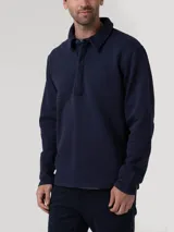 Buzo de algodón orgánico azul marino con cuello camisero, manga larga y medio cierre abotonado con solapa tapada.