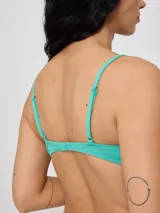Top de bikini con tirantes finos y escote redondo, confeccionado en poliamida con elastano, con estampado tropical en tonos verdes, celestes y salmón sobre fondo negro.