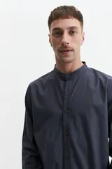 Camisa de hombre color gris con cuello mao, mangas largas y cierre abotonado. Confeccionada en algodón con look lino.